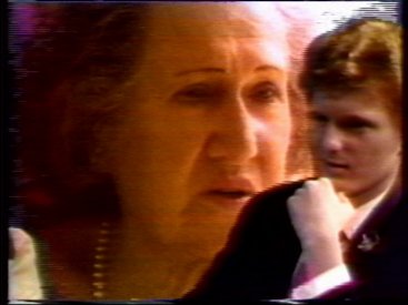 Kimble Rendall listens to Grandma Rose in a chrom-key playback of an interview with her.